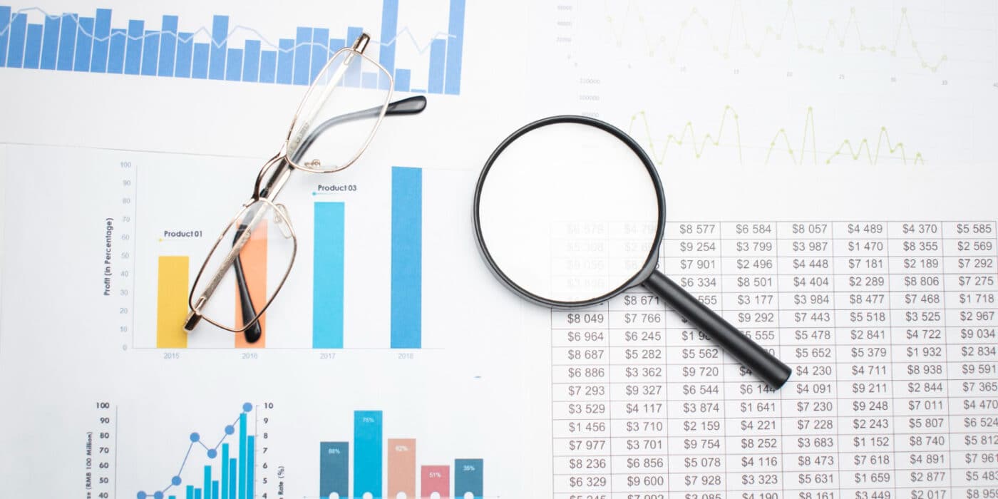 Business concept with calculator glasses pencil and magnifying glass on documents. Business grafs and charts
